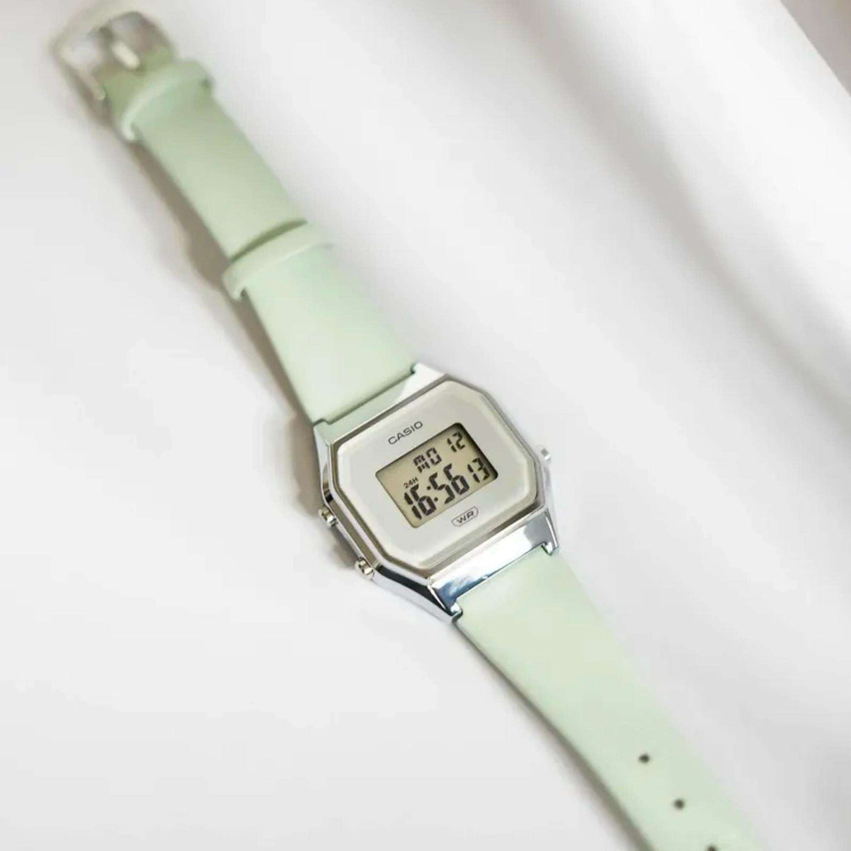 Mint green silicone strap with silver digital watch case, time readout visible