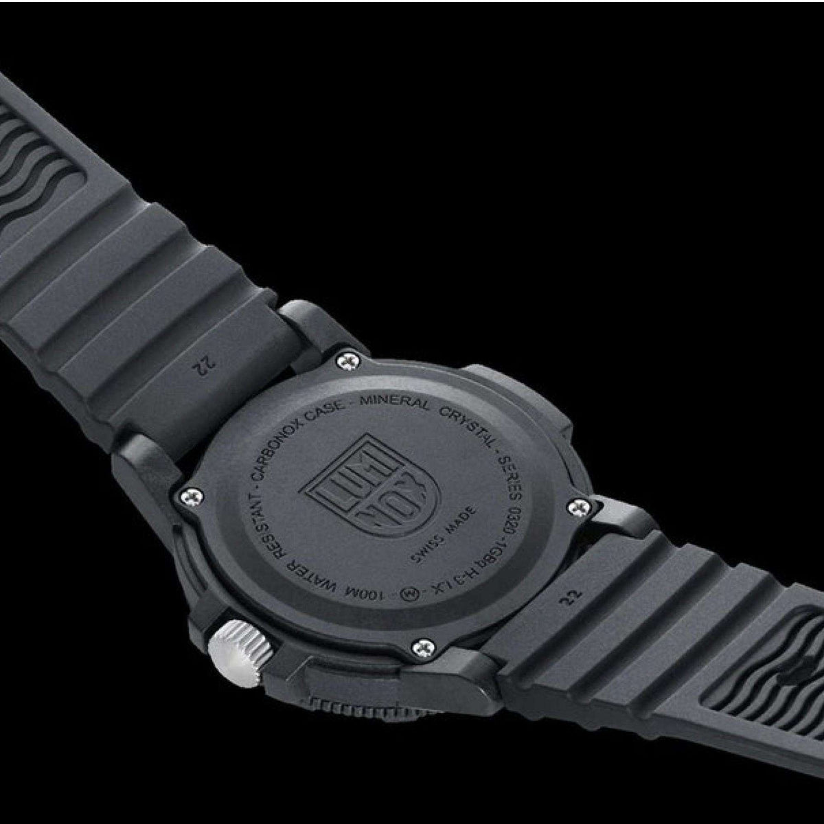Black rubber watch caseback close-up with engraved markings and protective edge