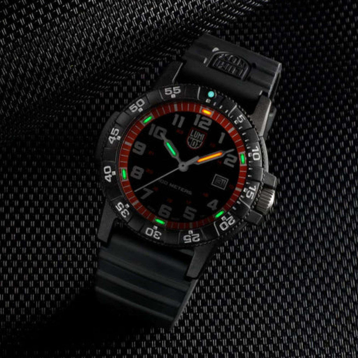 Black men’s sport watch on textured surface, orange outer ring, glowing hour markers