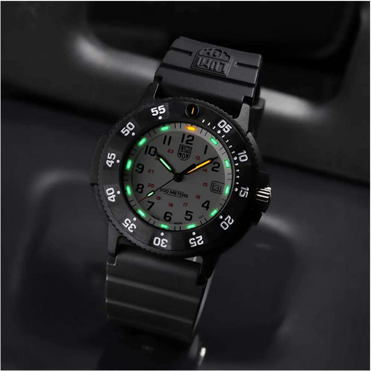 Men's dive watch on wrist with glowing dial markers and black bezel