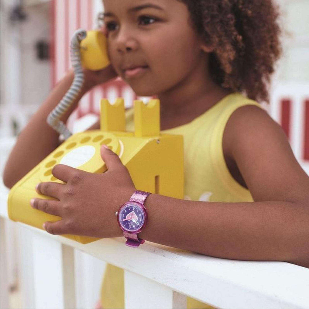 Flik Flak child's wristwatch on a child's arm with purple glitter strap