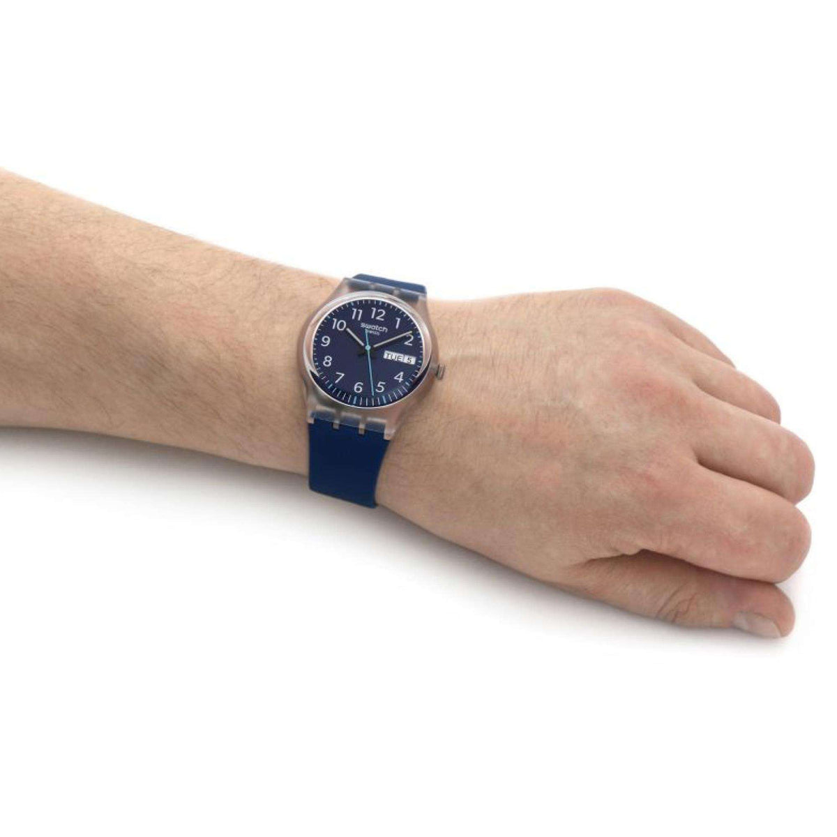 Navy blue dial watch on wrist, blue silicone band and silver case close-up