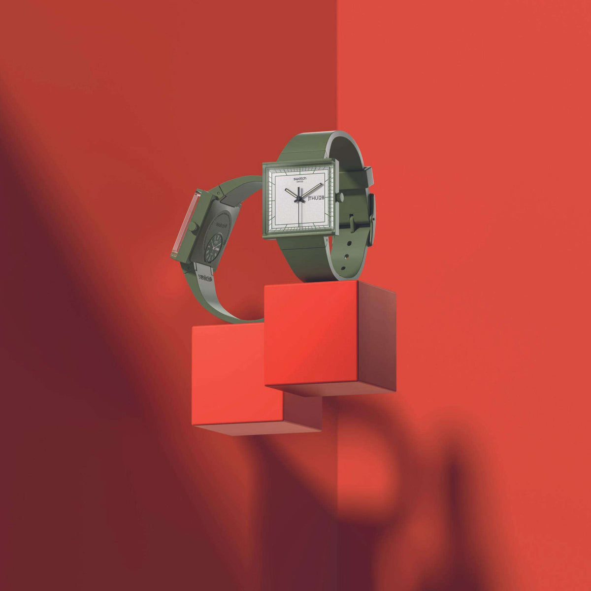 Square bioceramic watch in three-quarter view with green strap, white dial, side crown