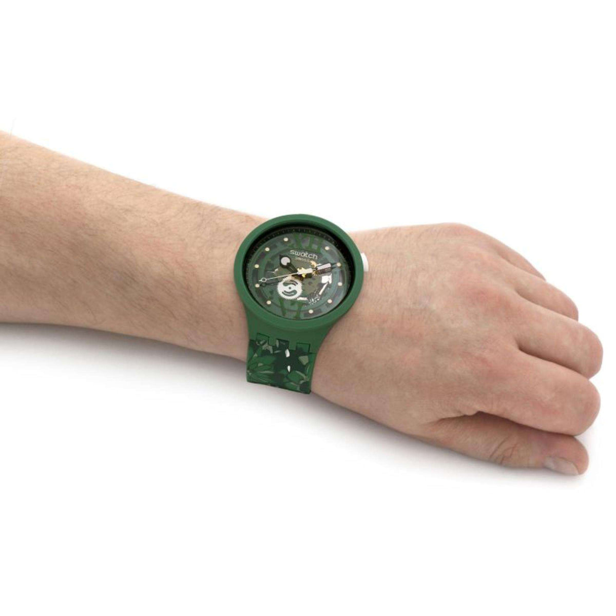 Swatch bioceramic watch on wrist with dark green camo strap and round dark dial