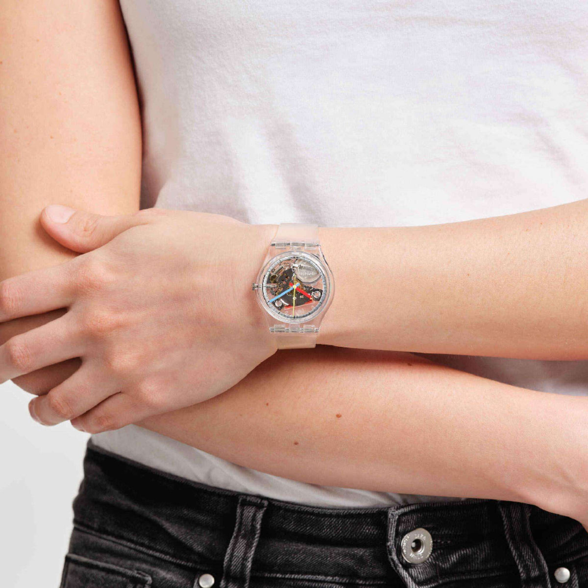 Swatch CLEARLY GENT Original watch on wrist; clear strap and colorful skeleton face
