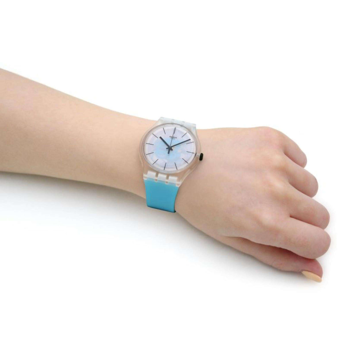 Swatch silicone strap watch worn on wrist, clear case with light blue dial