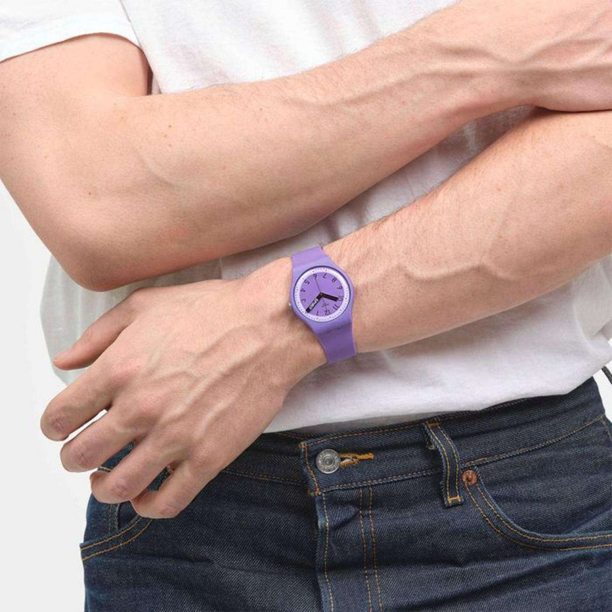 Purple silicone wristwatch on wrist over a white shirt cuff; round dial with black markers.