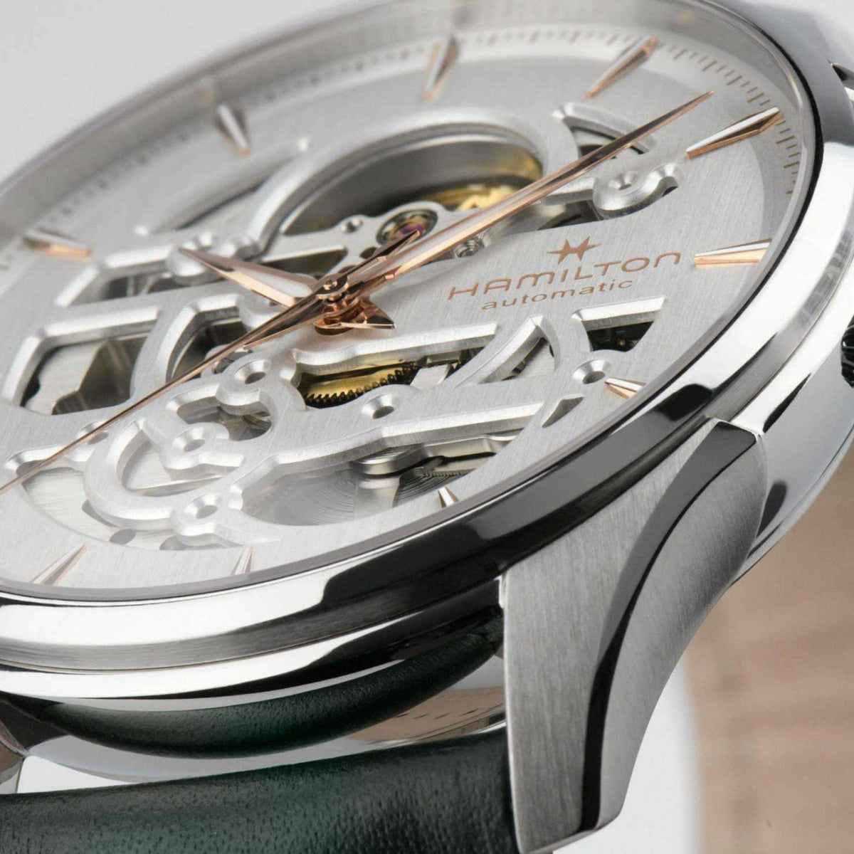 Close-up of a Hamilton Jazzmaster Skeleton watch with a white dial and rose gold hands
