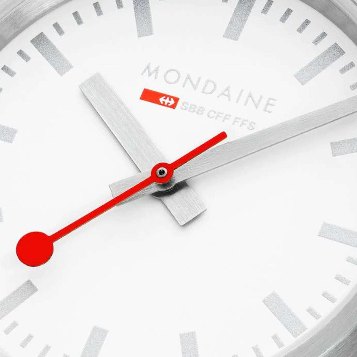 White dial close-up with red seconds hand, silver markers and Mondaine logo