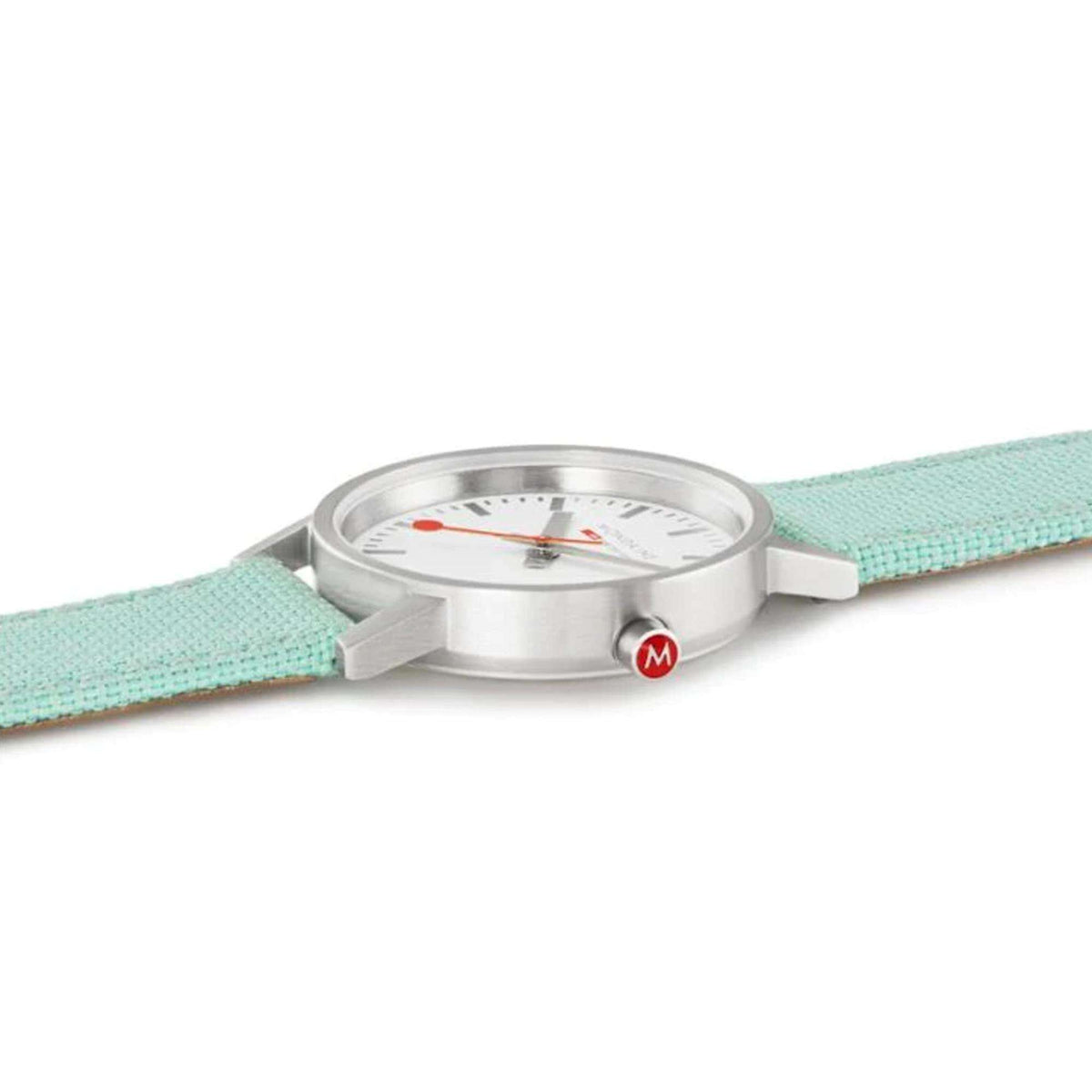 Round silver watch case with green textile band, crown at right side