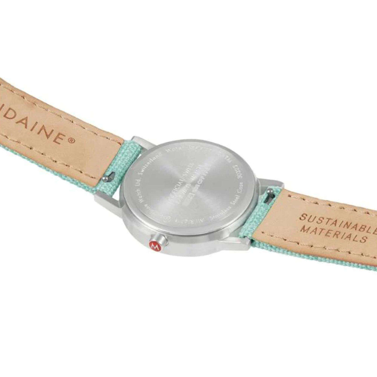 Back of silver watch case with green textile strap and 'SUSTAINABLE MATERIALS' text