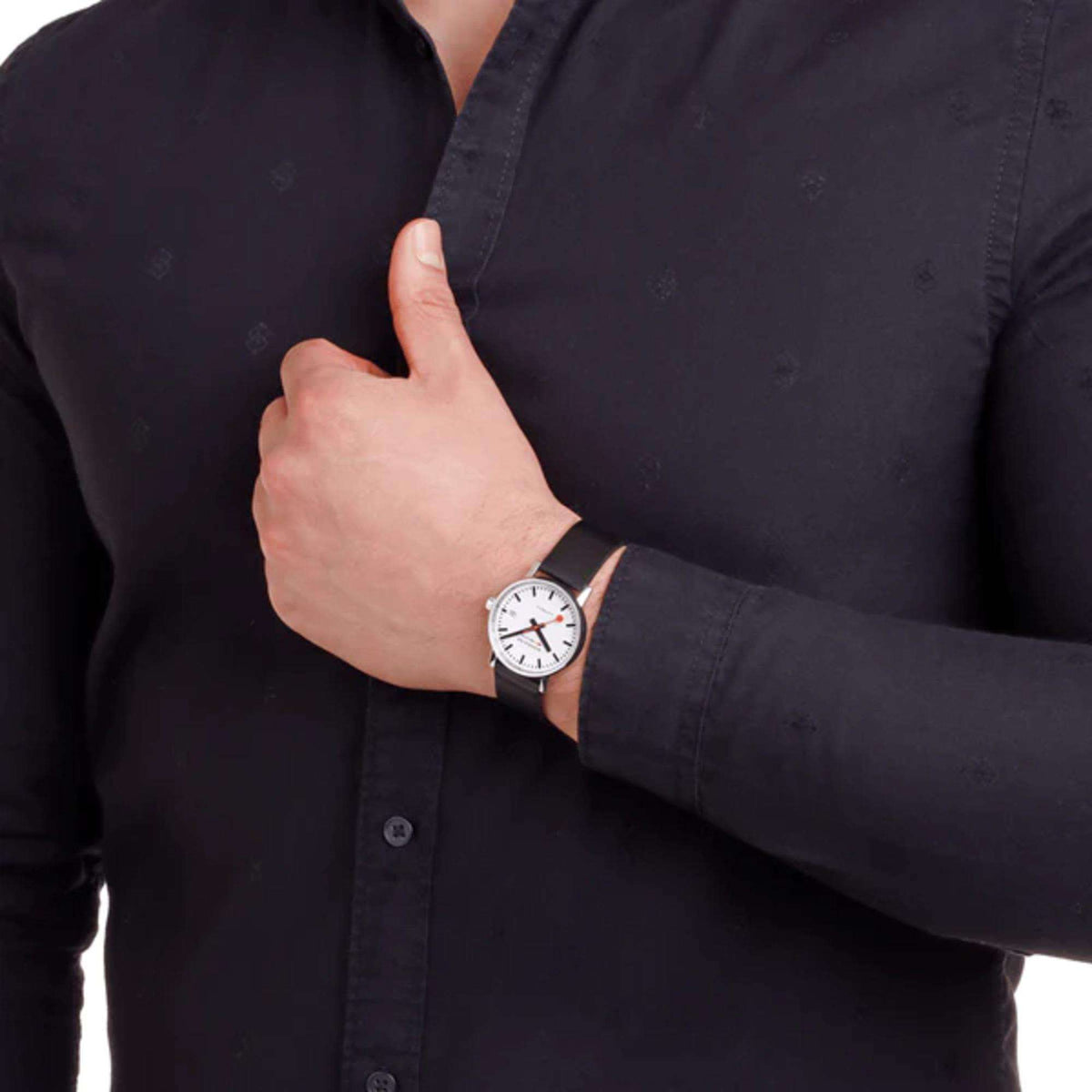 Automatic watch on wrist with white dial and black leather strap