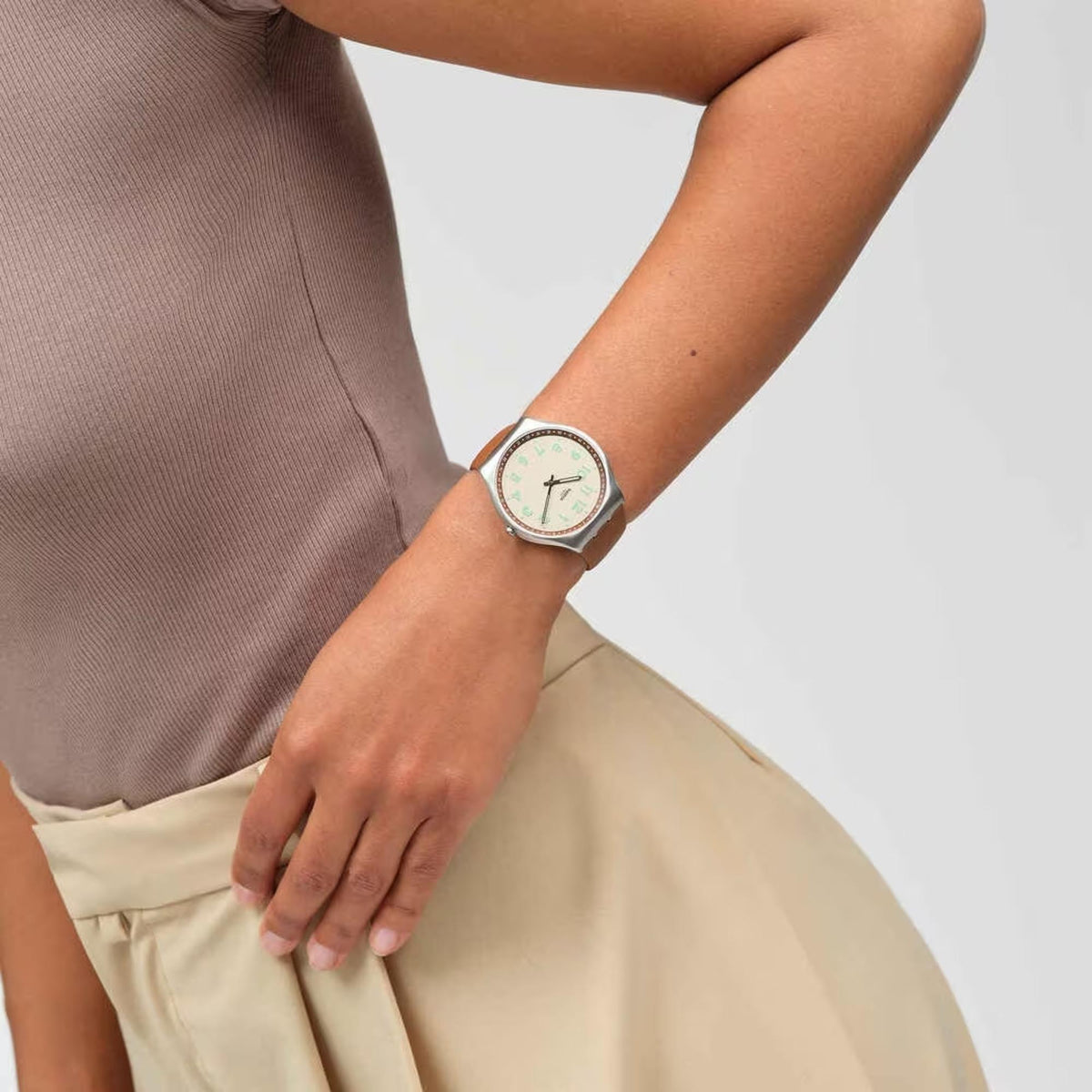 Beige dial leather watch with round silver case and brown strap, worn on wrist