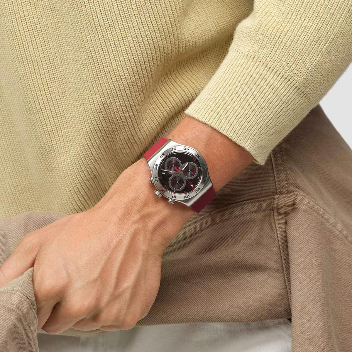 Red silicone strap watch on wrist; silver-tone case with red-black chronograph dial