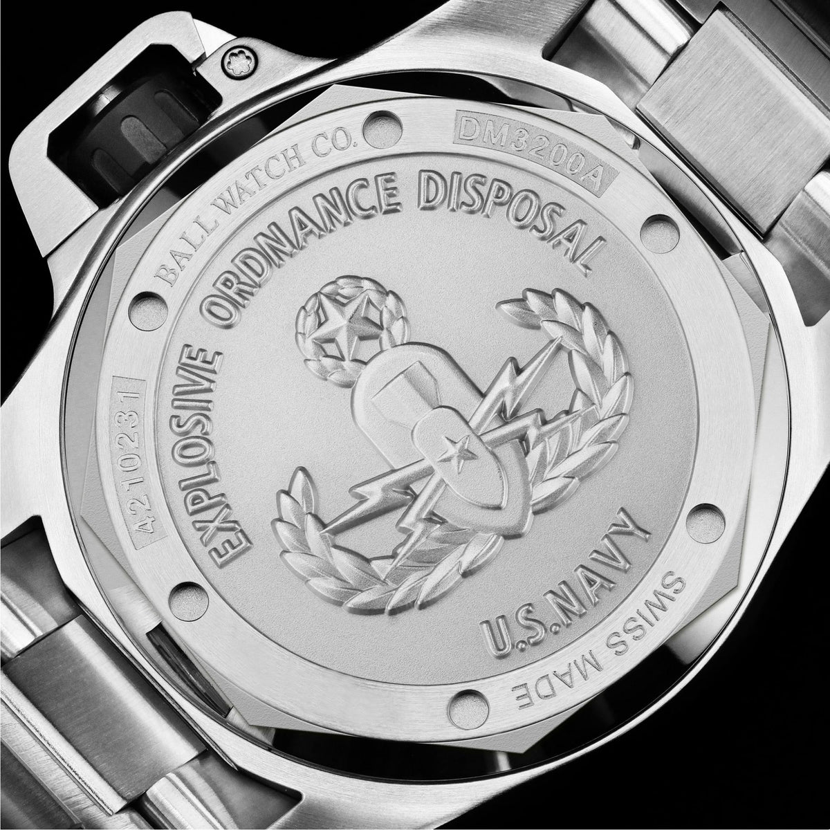 Stainless steel caseback with engraved insignia and text, visible screw details and markings