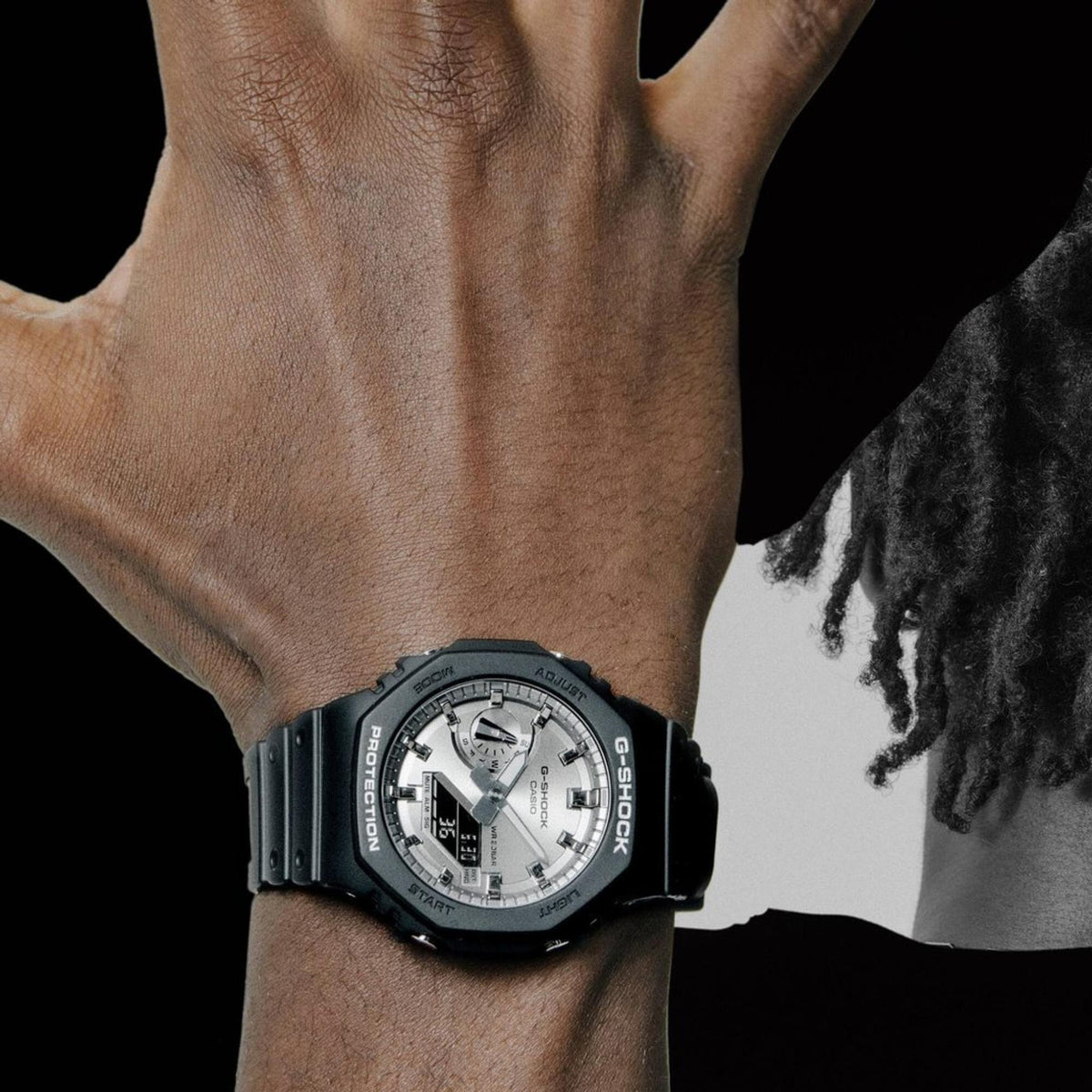 Men's Casio G-Shock quartz watch on wrist, silver dial with digital display, black strap.