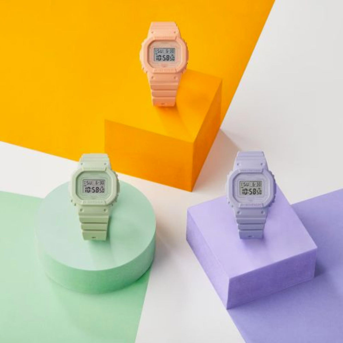 Pink resin digital G-Shock watch on colored display blocks with LCD screen