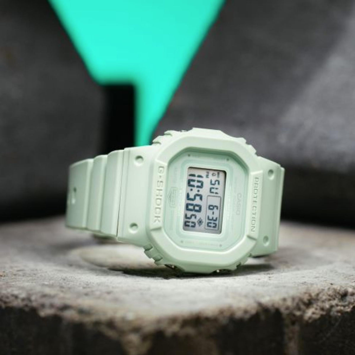 Green G-Shock digital watch resting on a surface, green resin band and display