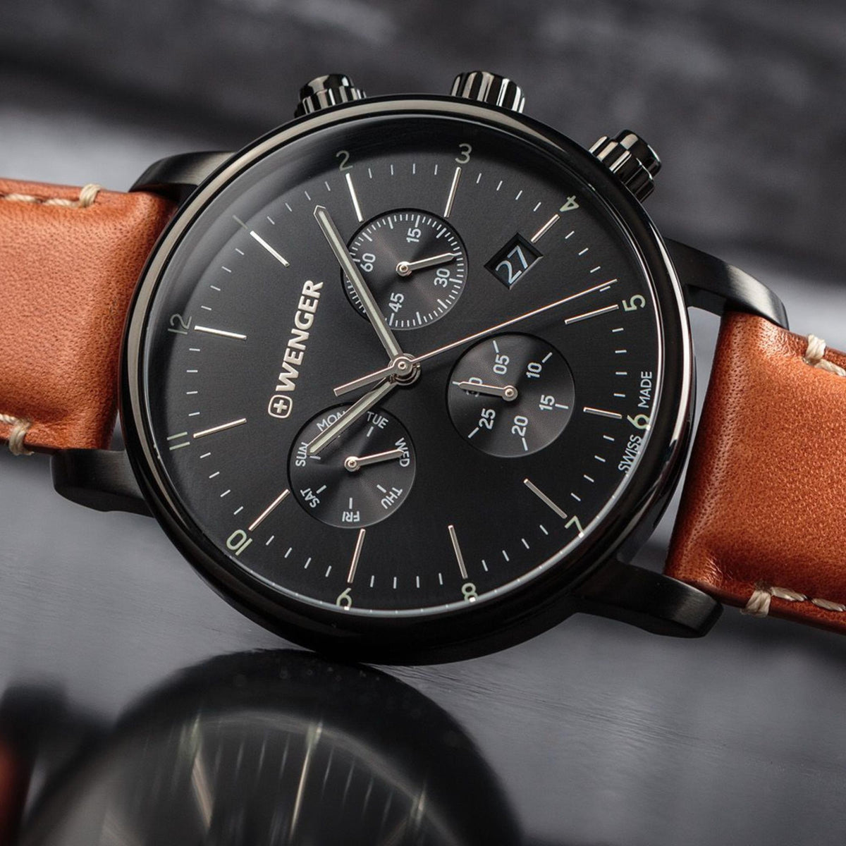 Men's chronograph watch with black dial, three subdials, and brown leather strap.
