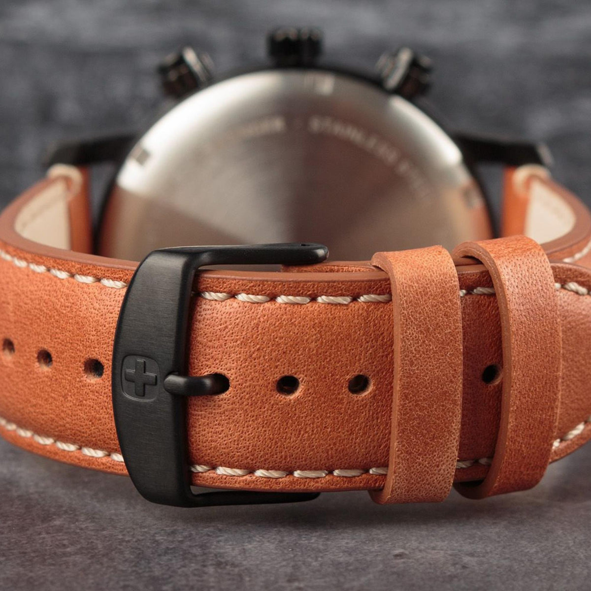Brown leather watch strap with black buckle and stitched holes for fit adjustment.