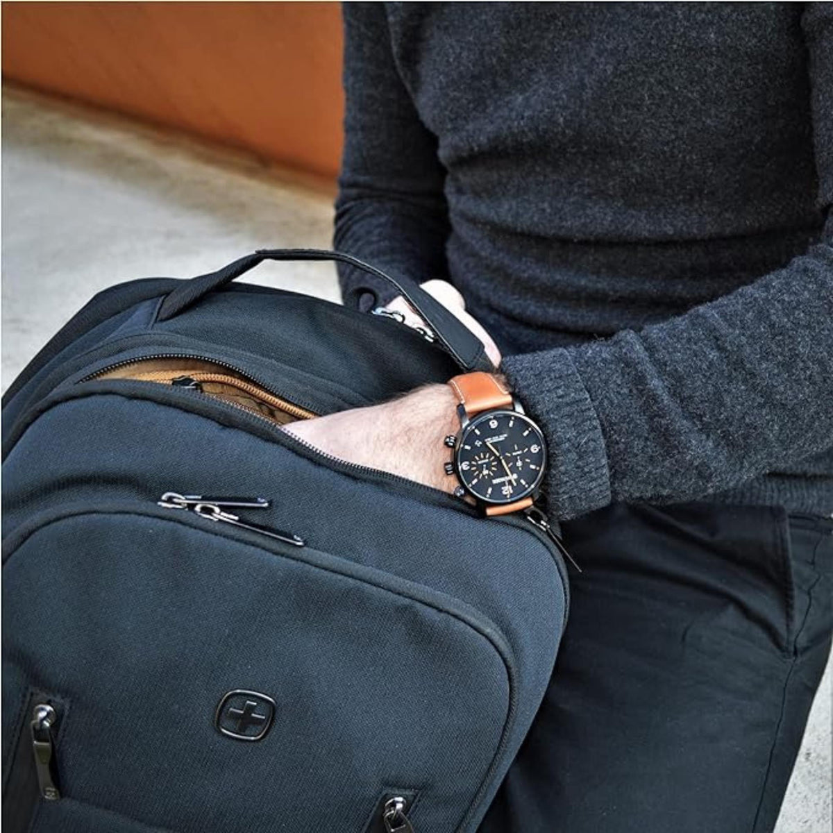 Men's Wenger chronograph quartz watch on wrist with brown leather strap, paired with jacket