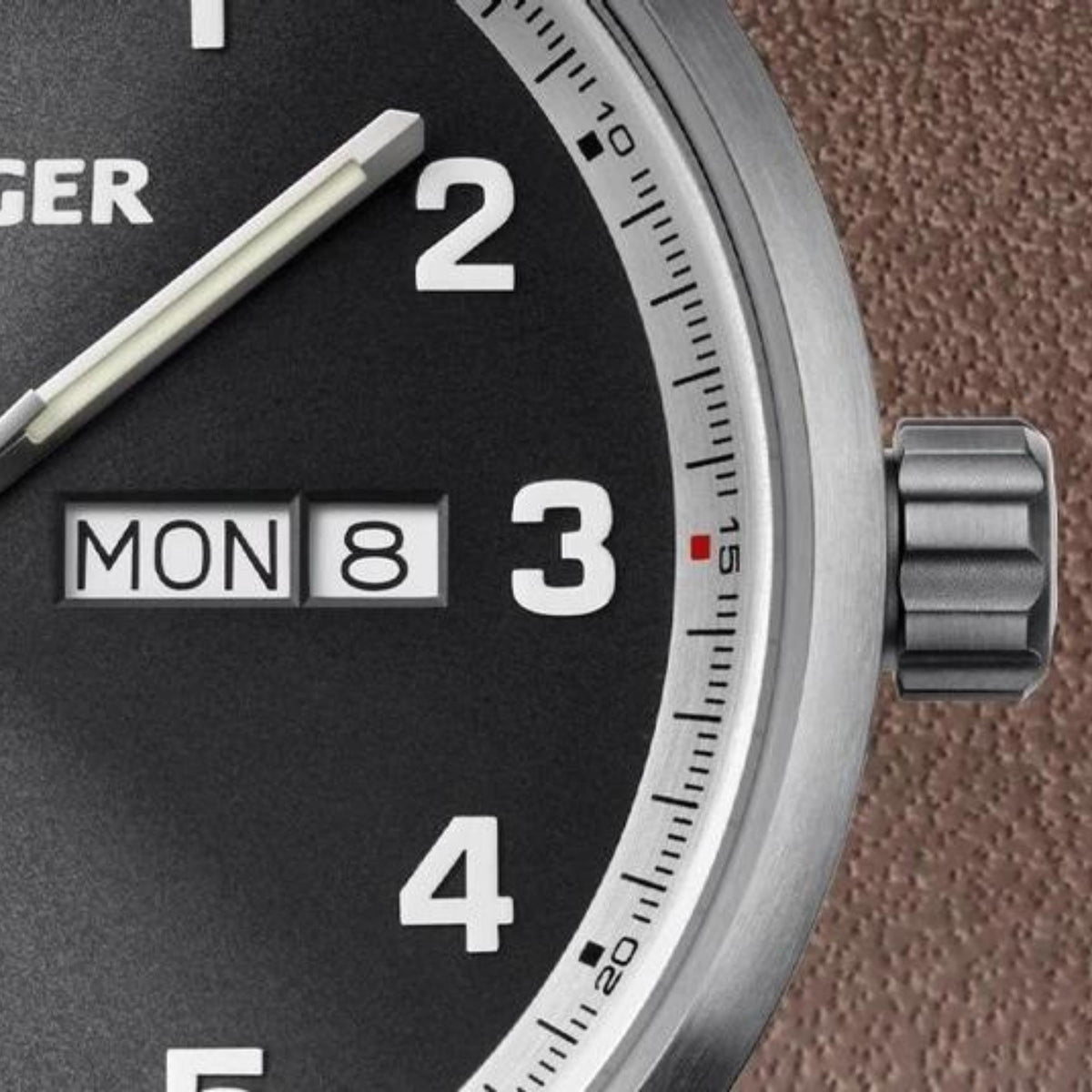 Men's quartz watch close-up with black dial, metal bezel, and steel crown at 3 o'clock