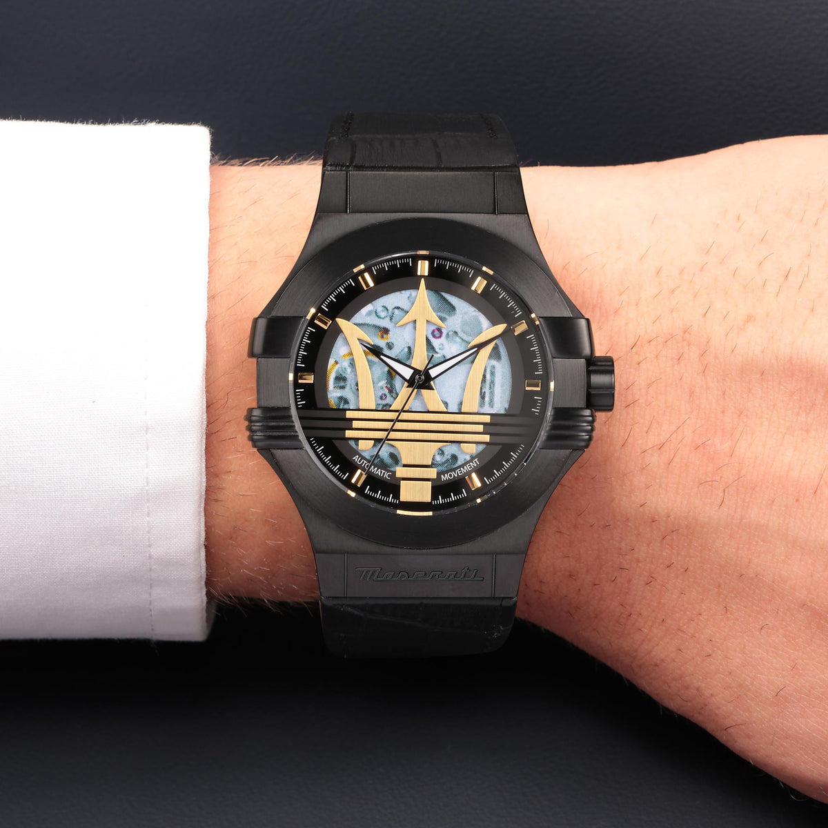 Men's black leather skeleton dial quartz watch on wrist, gold hour markers visible