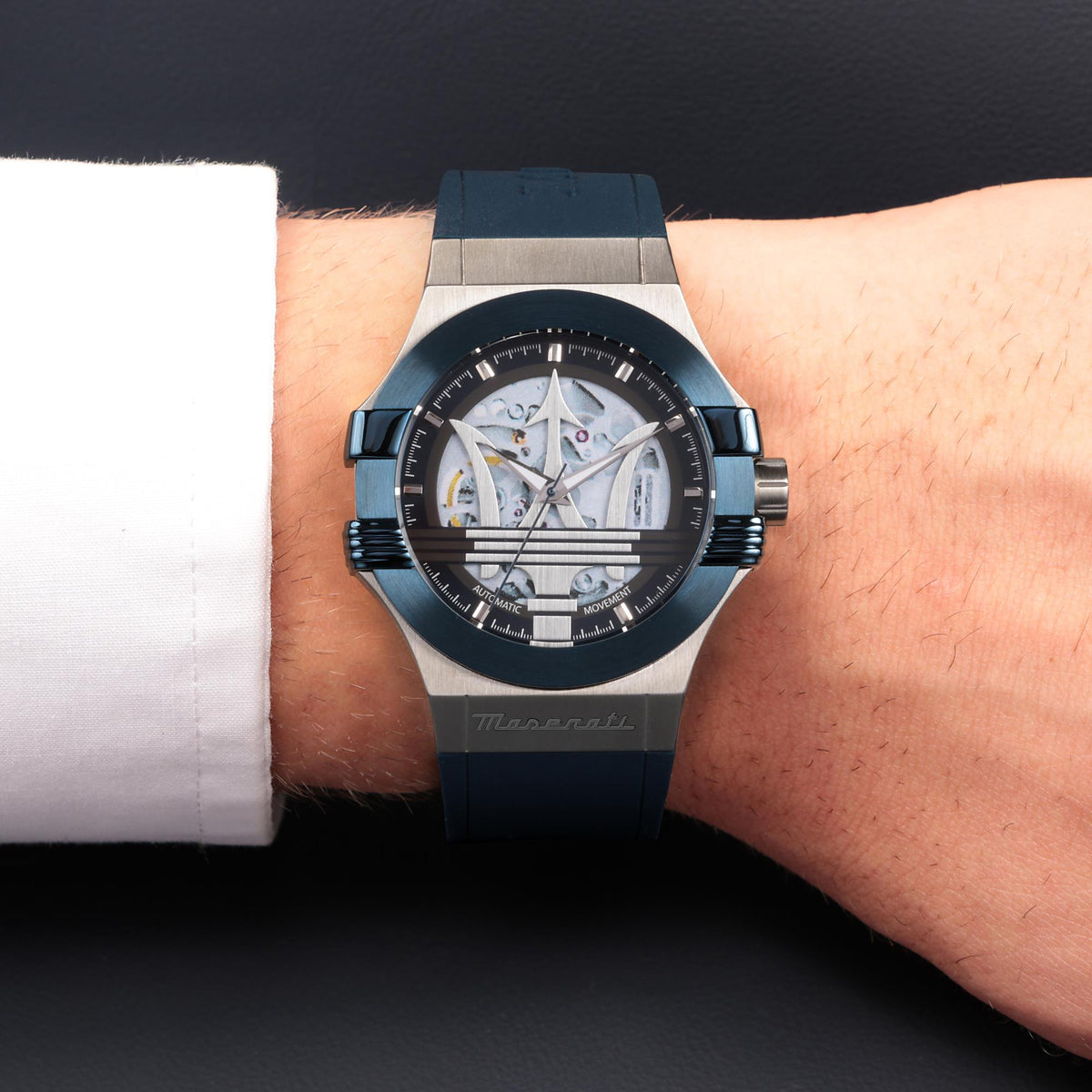 Men's skeleton quartz watch on wrist with blue silicone strap and metal case