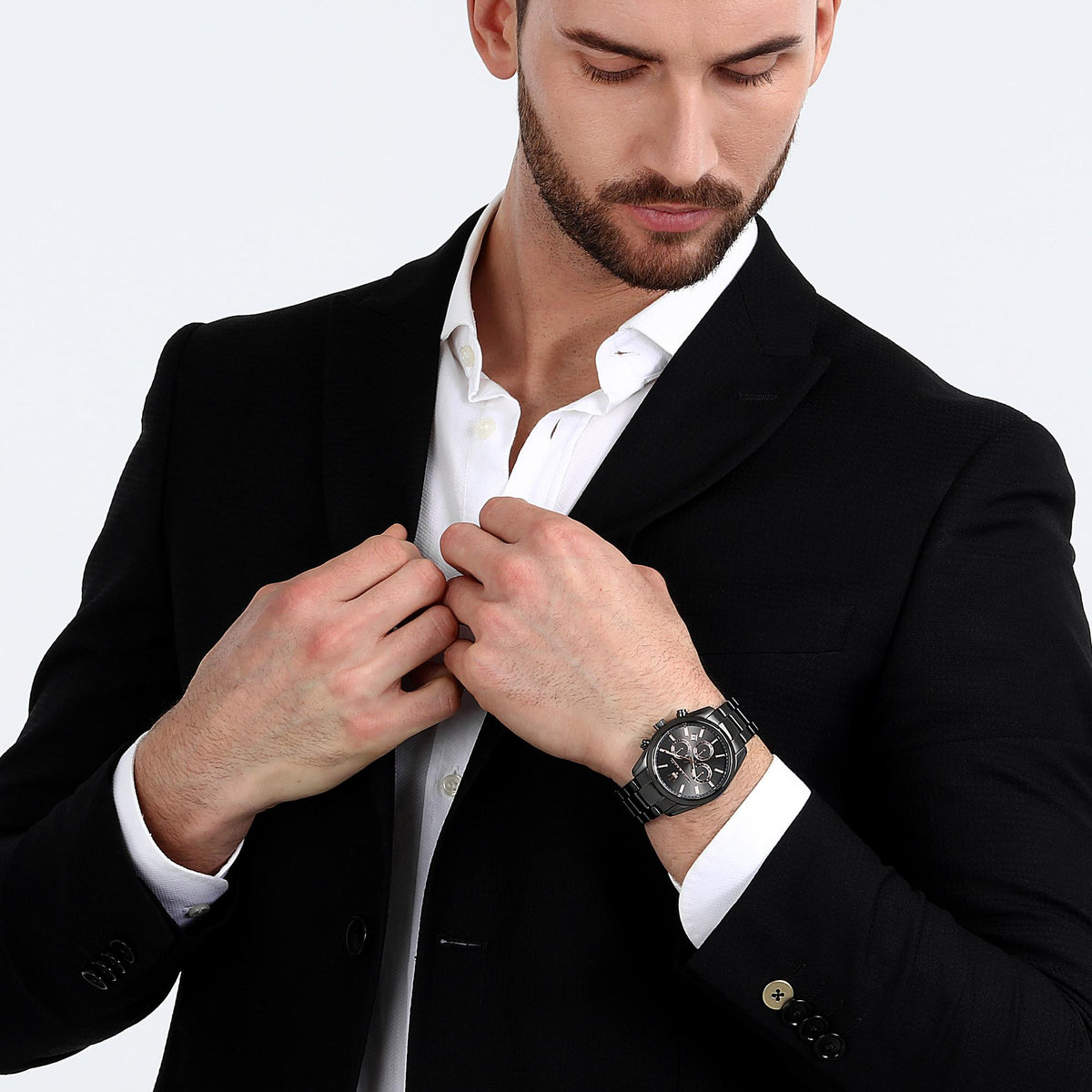Men's black chronograph watch on wrist with black dial and steel bracelet