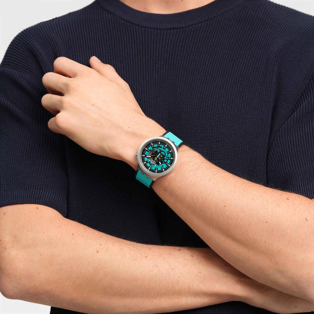 Unisex wristwatch on model: turquoise strap with teal dial and gray case