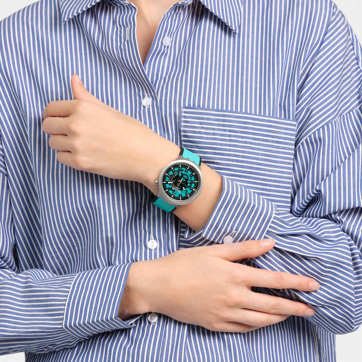Unisex wristwatch on model: turquoise rubber strap, teal dial, gray case on wrist