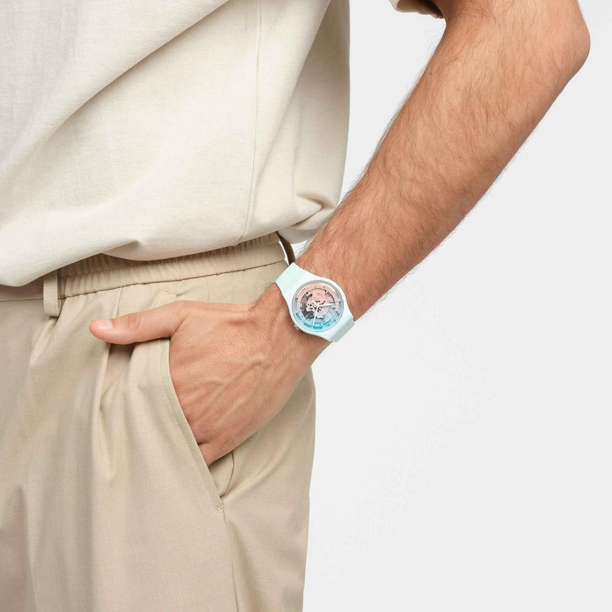 Unisex mint silicone watch worn on wrist, ice-blue and pink skeleton dial