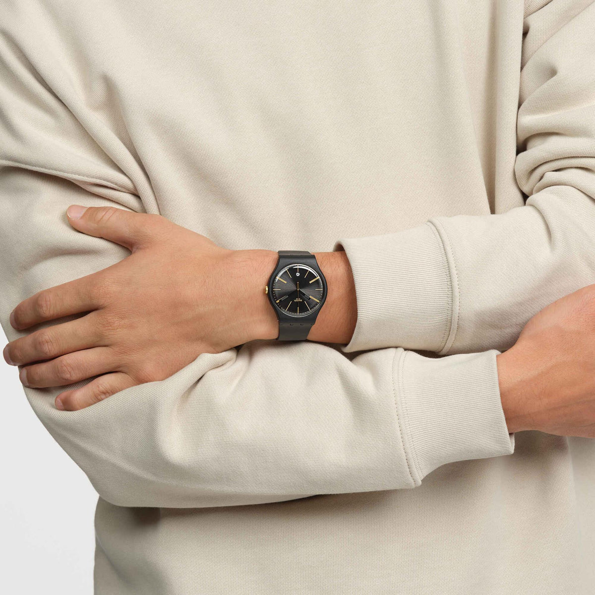 Unisex black silicone watch on wrist, dark dial with gold markers and hour hand