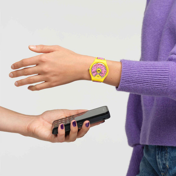 Unisex watch on wrist with yellow silicone strap and pink cartoon donut dial