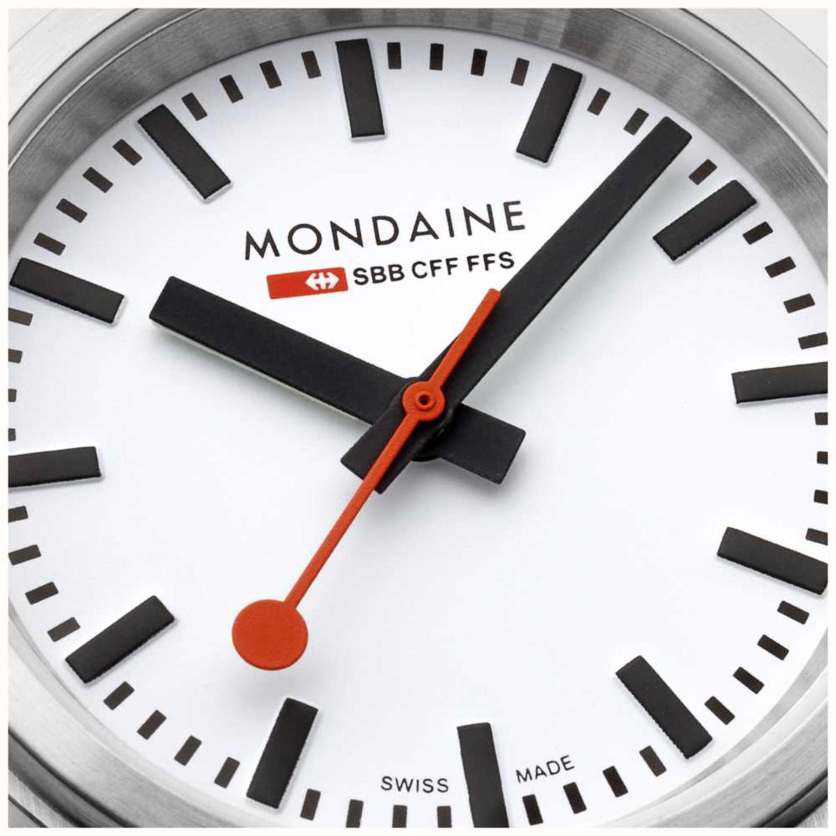 Mondaine white dial close-up with orange seconds hand and black hour markers