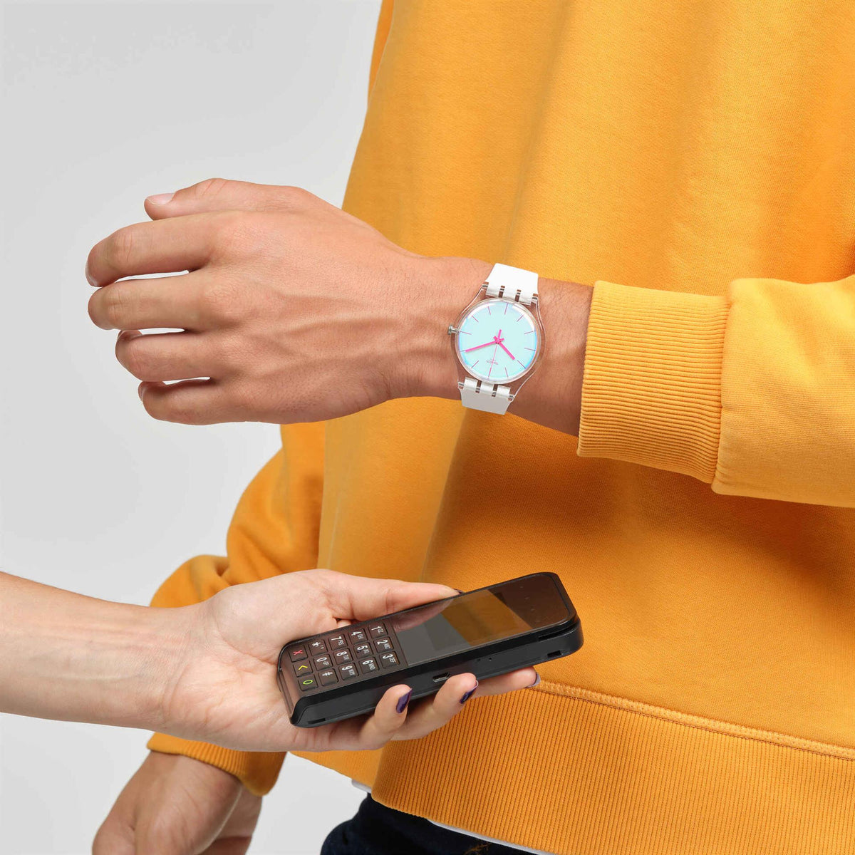 Swatch silicone watch on wrist, white band and light dial with pink hands