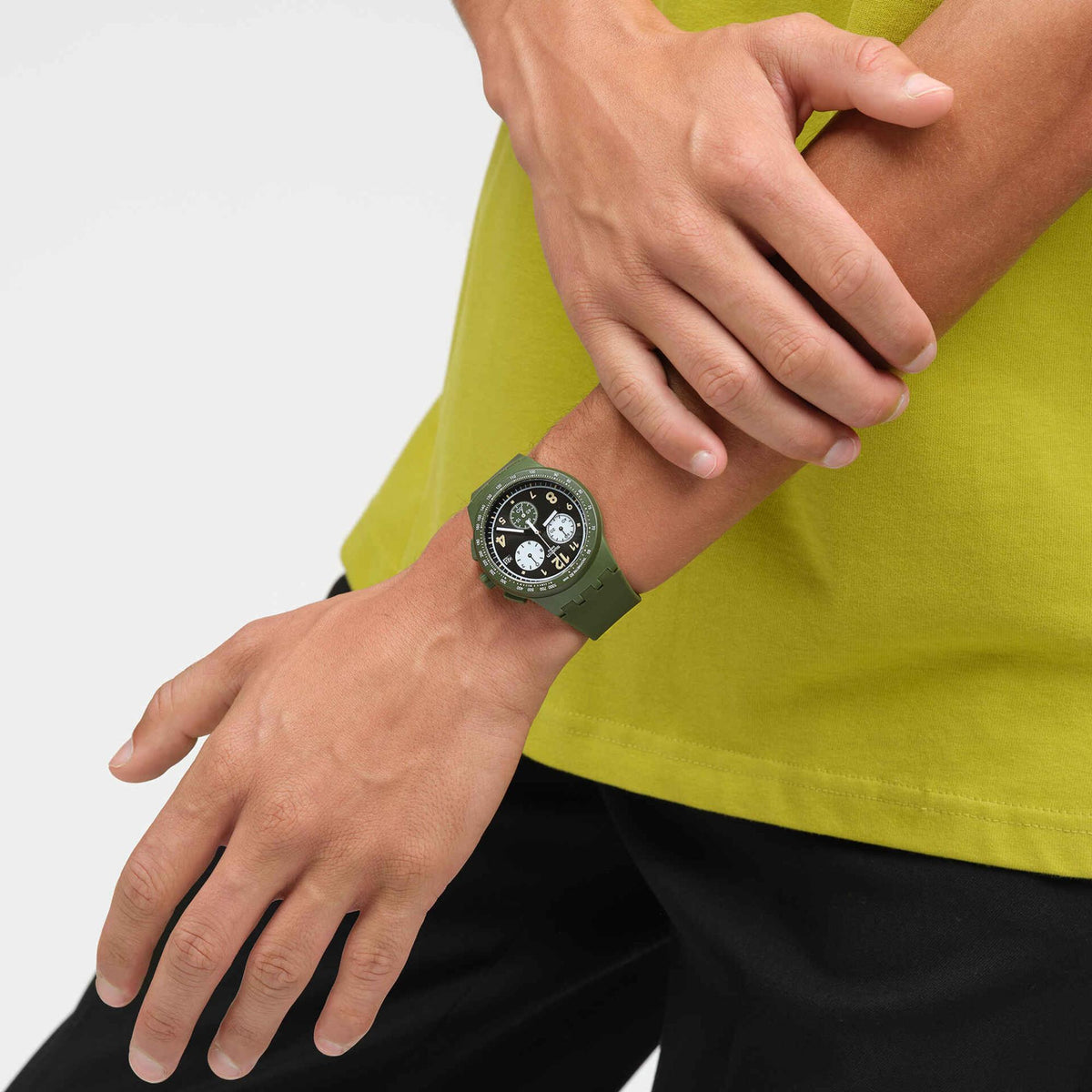 Quartz watch on wrist with green silicone strap and dark dial with subdials