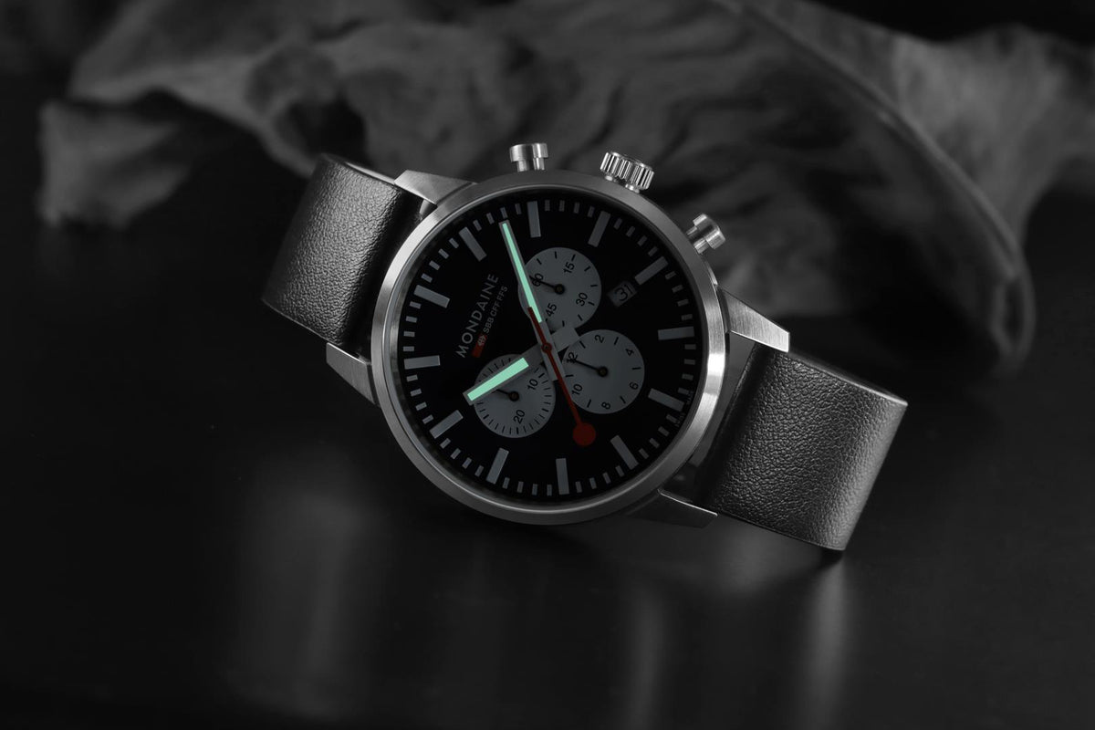 Mondaine Neo MSD.41420.LBV angled view showing luminous hands glowing on black dial