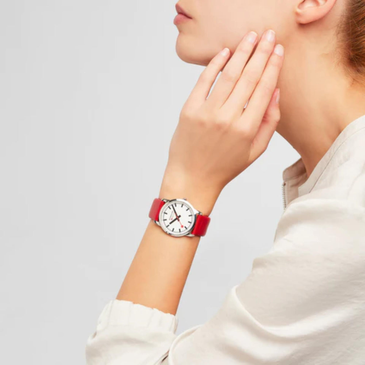 Red leather quartz watch on wrist with white dial and black index markers