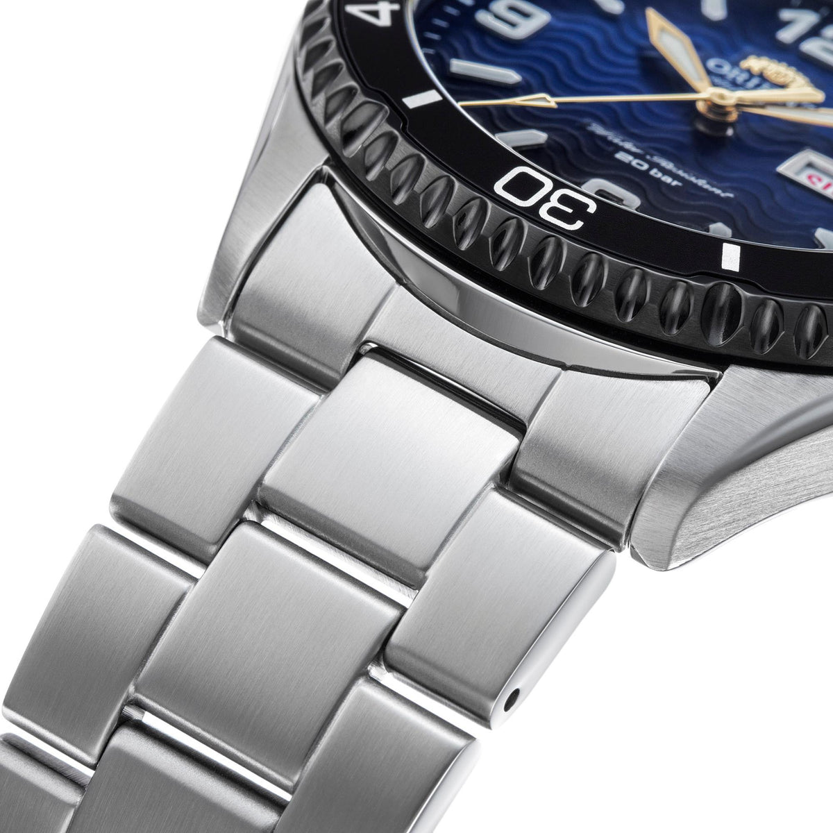 Stainless steel bracelet links and case edge of a blue-dial diver-style watch