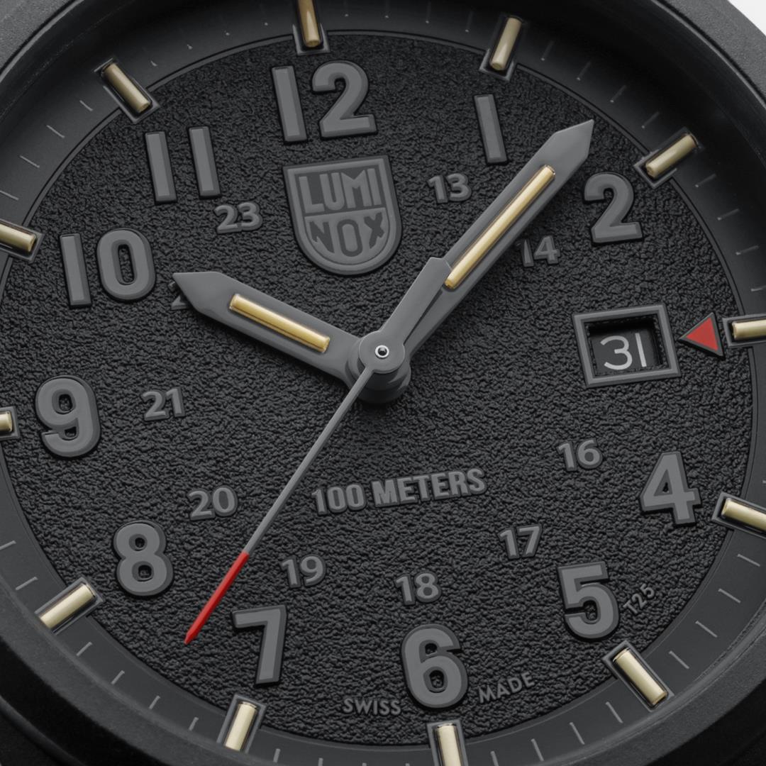 Close-up of dark dial quartz watch with luminous markers and "100 METERS" text