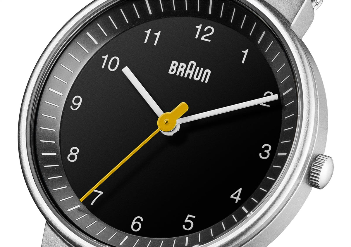Ladies quartz watch close-up: black dial, BRAUN logo, silver hands with yellow center