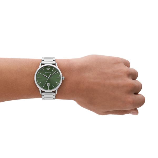 Men's steel quartz watch on wrist with green dial and metal bracelet.