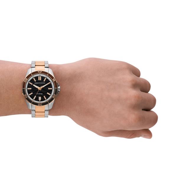 Men's quartz watch on wrist, black dial with rose-gold and silver metal bracelet.