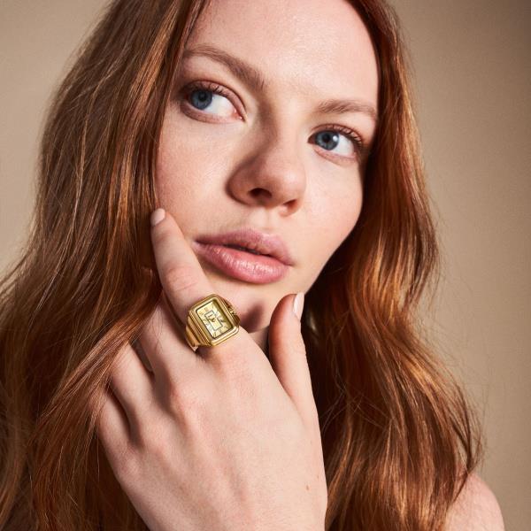 On-finger lifestyle view of the Fossil Watch Ring ES5343 highlighting the compact gold dial and gold-tone steel ring band