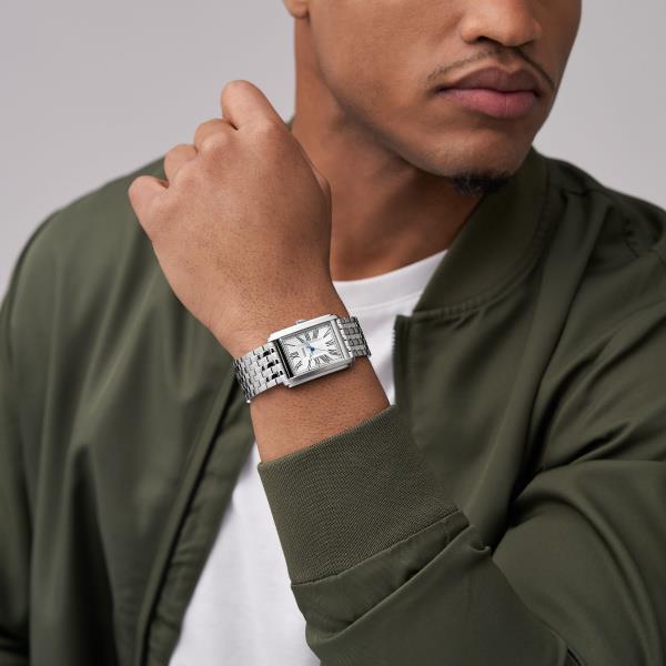 Men's steel quartz watch on wrist with white dial and Roman numeral markers