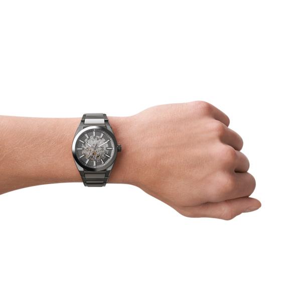 Fossil Everett ME3206 42mm mechanical timepiece worn on wrist, showing the openwork grey dial and gunmetal stainless steel bracelet