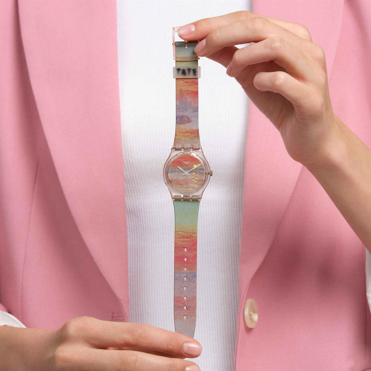 Multicolor silicone strap wristwatch with clear round dial worn on a person’s wrist