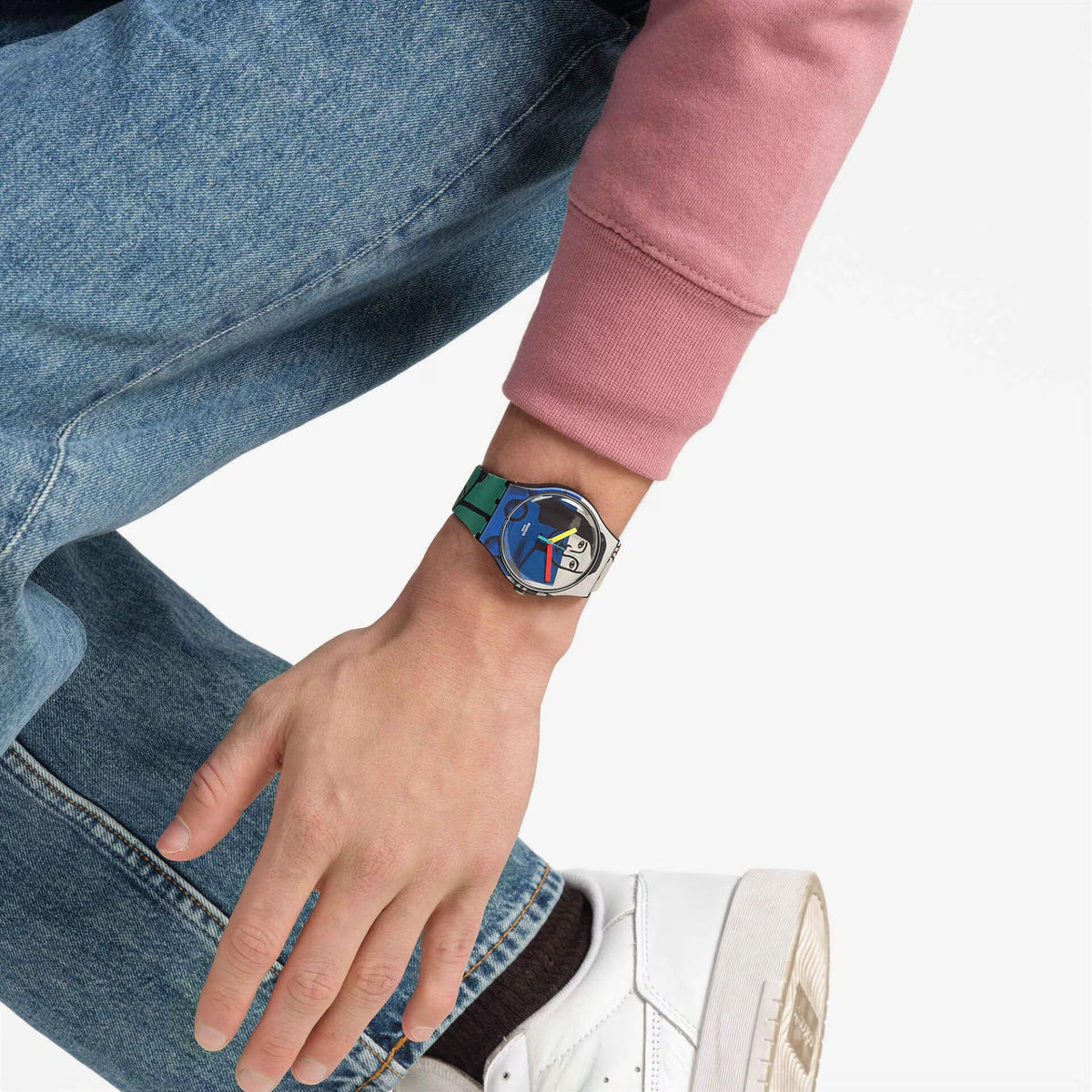 Silicone strap watch on wrist with denim and pink sleeve, illustrated blue dial
