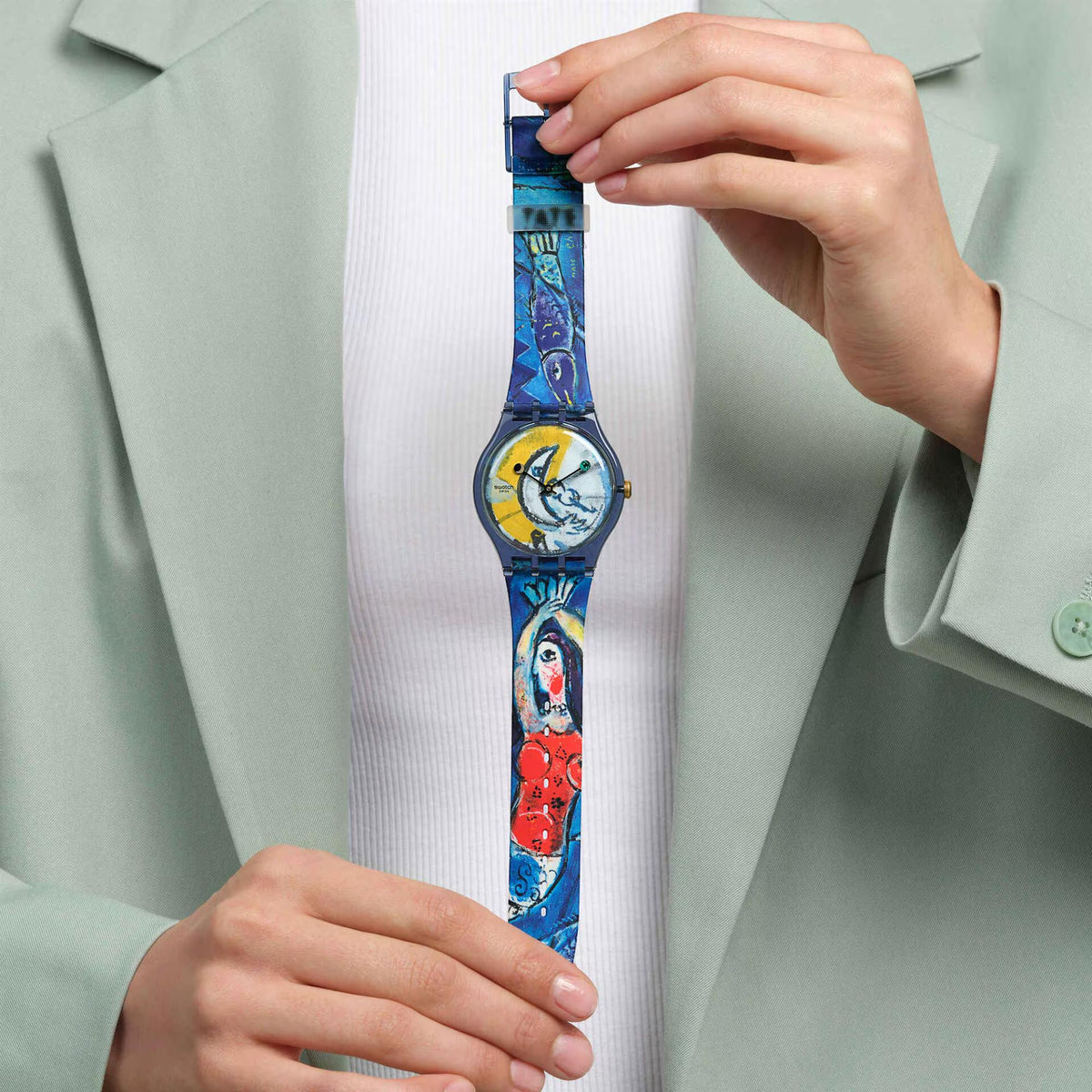 Swatch silicone strap watch on wrist, colorful circus dial and gold-toned crown
